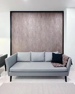 a couch sitting in a room with a wall at Luxury Suites at Tropicana Residences KLCC by VV in Kuala Lumpur