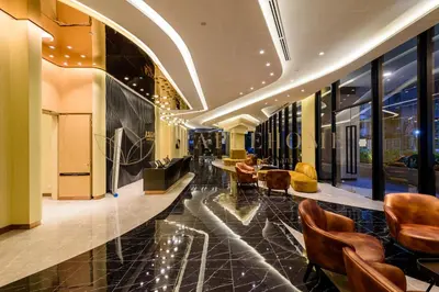 a lobby with chairs and tables in a building at Axon Premier Suites Kuala Lumpur in Kuala Lumpur