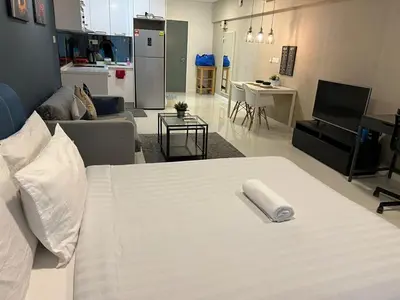 a bedroom with a white bed and a living room at Summer suites near klcc in Kuala Lumpur