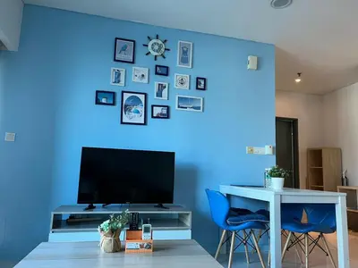 a room with a blue wall with a table and a tv at Summer suites near klcc in Kuala Lumpur