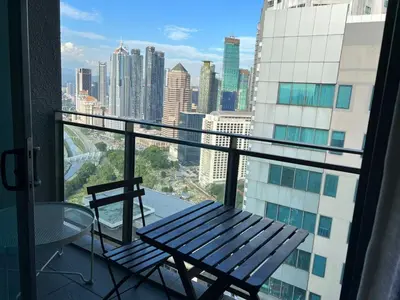 a balcony with a bench and a view of a city at Summer suites near klcc in Kuala Lumpur