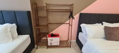 a bedroom with two beds and a book shelf between them at Arcoris Mont Kiara 163 in Kuala Lumpur