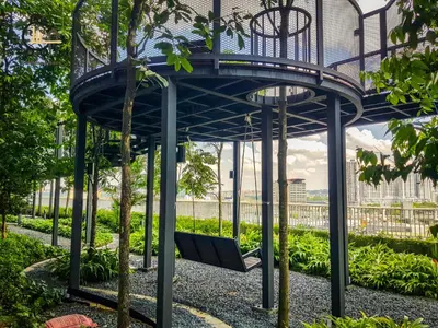 a blue bench in a park with trees at 1 min to KL Tallest Residence Heart of Klang Valley in Kuala Lumpur