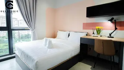 a bedroom with a bed and a desk with a computer at NeuSuite Cozy Studio by GUESTONIC in Kuala Lumpur