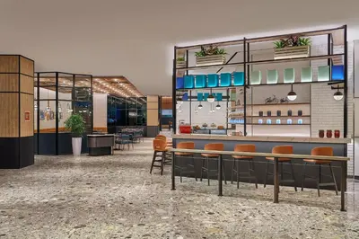 a lobby with a bar with orange chairs at Four Points by Sheraton Kuala Lumpur, City Centre in Kuala Lumpur