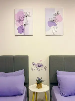 two beds with purple and purple pillows and a table at SETAPAK CENTRAL KL - Lavender Zetapark Suite in Kuala Lumpur