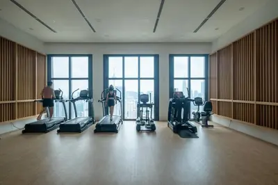 a gym with people exercising in a large room with windows at Cute Dinosaur Kids Theme@Lucentia LalaPort BBCC in Kuala Lumpur