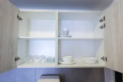 a white cabinet with bowls and dishes in it at M Vertica KL Residence in Kuala Lumpur