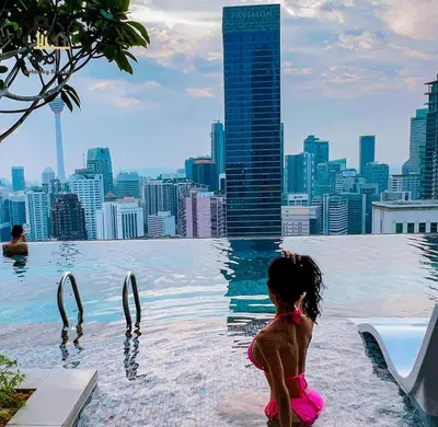 a little girl sitting in a infinity pool with a city skyline at 1 min to Pavilion KL Heart of Bukit Bintang by GBS in Kuala Lumpur
