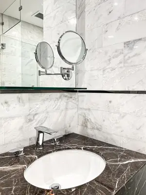 a bathroom with a sink and two mirrors at KL Tower KLCC Pavilion by Kimiro in Kuala Lumpur