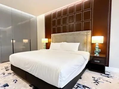 a bedroom with a large white bed with a large headboard at KL Tower KLCC Pavilion by Kimiro in Kuala Lumpur