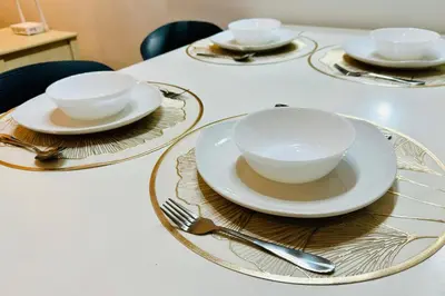 three plates and bowls on a table with silverware at Comfy-Concept Apartment @ B.Bintang (3min walk LRT, Lalaport, TimeSquare) in Kuala Lumpur