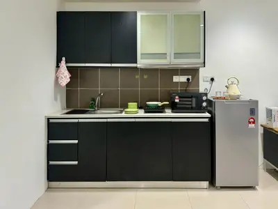 a kitchen with black cabinets and a stainless steel refrigerator at Comfy-Concept Apartment @ B.Bintang (3min walk LRT, Lalaport, TimeSquare) in Kuala Lumpur