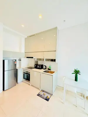 a kitchen with white cabinets and a sink and a table at BBCC APARTMENT AT LUCENTIA 2 in Kuala Lumpur