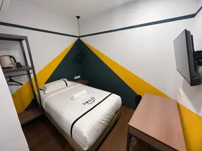 a small room with a bed and a tv at Seeds Hotel Chow Kit in Kuala Lumpur