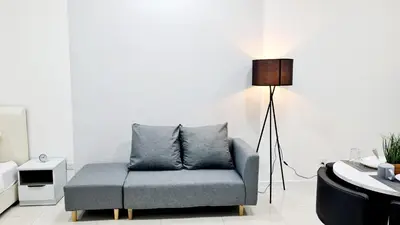 a living room with a blue couch and a lamp at Kualalampur Chambers KLCC By Sky Pool in Kuala Lumpur