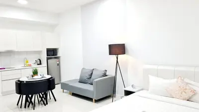 a bedroom with a bed and a chair and a kitchen at Kualalampur Chambers KLCC By Sky Pool in Kuala Lumpur