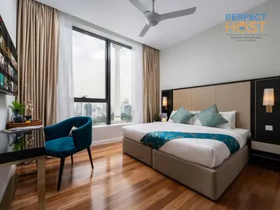 a hotel room with a bed and a blue chair at Pavilion Ceylon Hill Suites, Bukit Bintang by Perfect Host in Kuala Lumpur