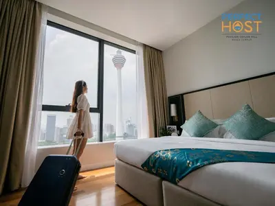 a woman standing in a hotel room looking out the window at Pavilion Ceylon Hill Suites, Bukit Bintang by Perfect Host in Kuala Lumpur