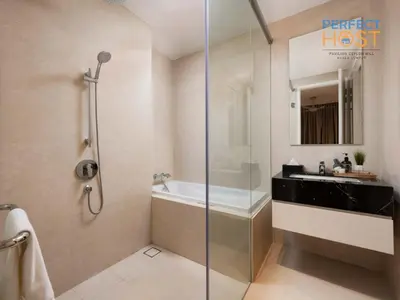 a bathroom with a shower and a tub and a sink at Pavilion Ceylon Hill Suites, Bukit Bintang by Perfect Host in Kuala Lumpur