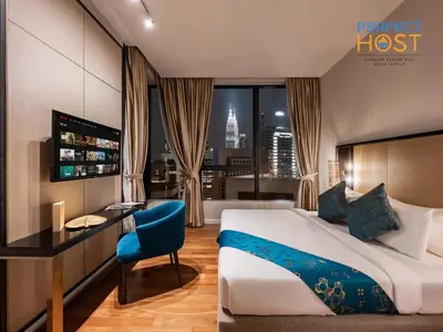 a hotel room with a bed and a desk and a room with a view at Pavilion Ceylon Hill Suites, Bukit Bintang by Perfect Host in Kuala Lumpur