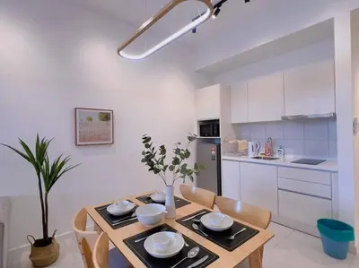 a kitchen with a wooden table with chairs and a dining room at Cozy & Homely Chambers KL@3 Mins Walking Distance to LRT & Monorail in Kuala Lumpur