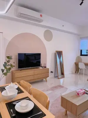 a living room with a television and a table with chairs at Cozy & Homely Chambers KL@3 Mins Walking Distance to LRT & Monorail in Kuala Lumpur