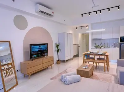 a living room with a flat screen tv and a table at Comfy & Cozy Chambers KL, Near PWTC & Sunway Putra Mall in Kuala Lumpur