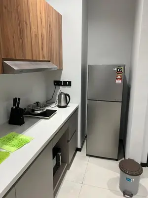 a kitchen with a stainless steel refrigerator and cabinets at Opus Residences 1 Bedroom Apartment in Kuala Lumpur