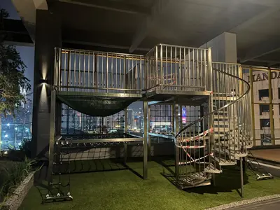 a spiral staircase in a room with a view of a city at Opus Residences 1 Bedroom Apartment in Kuala Lumpur