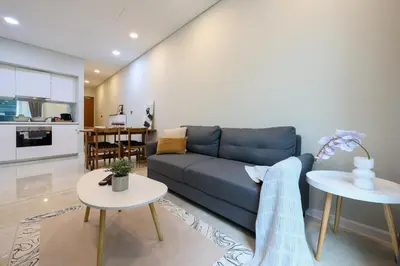 a living room with a blue couch and a table at Sky Suites KLCC By Calm Sojourn in Kuala Lumpur