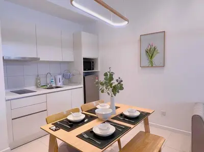 a kitchen with a wooden table with plates on it at Spacious Connecting Room 4px, Chambers Residence KL, Walking Distance to LRT, MRT, Sunway Putra Mall & PWTC in Kuala Lumpur