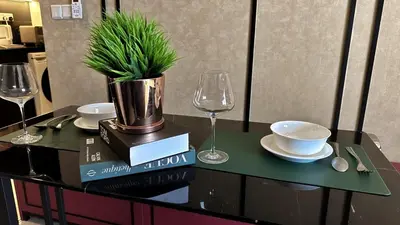 a table with a potted plant and a wine glass at The Ress - The Axon Bukit Bintang Residence in Kuala Lumpur
