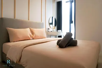 a teddy bear sitting on top of a bed at The Ress - The Axon Bukit Bintang Residence in Kuala Lumpur