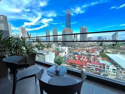 a balcony with tables and chairs and a view of a city at Axon Suites Bukit Bintang by Prestige in Kuala Lumpur