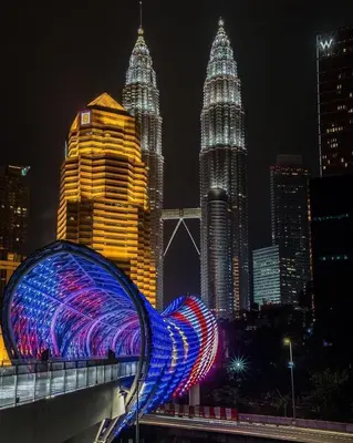 a blue lighted sculpture on a bridge in a city at night at Axon Suites Bukit Bintang by Prestige in Kuala Lumpur