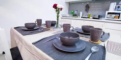 a table with cups and plates on it in a kitchen at EkoCheras Loft 5 pax, #SoccerTable #AboveMall #Cozy #FreeCarPark in Kuala Lumpur