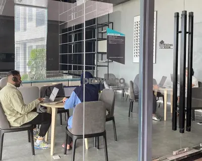 a group of people sitting at a table with laptops at Continew at 35 floor - 5pax - KL - TRX - 2 Bedroom in Kuala Lumpur