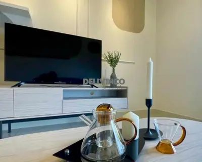 a living room with a tv and a table with a glass pitcher at Continew at 35 floor - 5pax - KL - TRX - 2 Bedroom in Kuala Lumpur