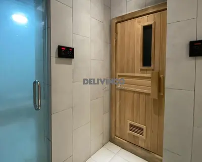 a bathroom with a wooden door and a shower at The Luxe - KLCC View - 3 pax Balcony at 41 floor in Kuala Lumpur