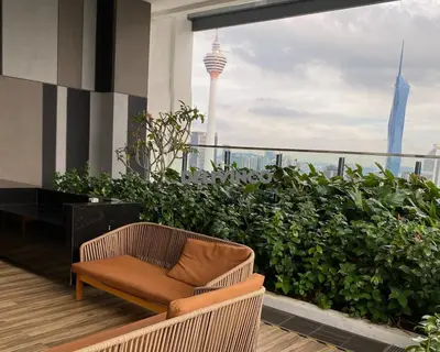 a chair on a balcony with a view of the city at The Luxe - KLCC View - 3 pax Balcony at 41 floor in Kuala Lumpur