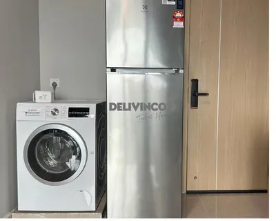 a stainless steel refrigerator next to a washing machine at The Luxe - Balcony at 42 floor - KLCC View - 3 pax in Kuala Lumpur