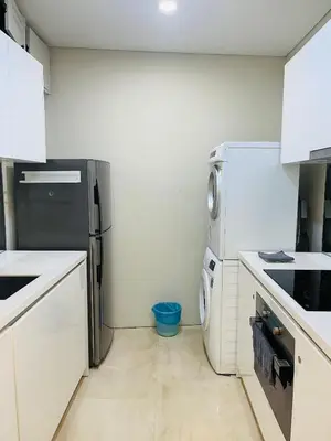 a kitchen with white cabinets and a black refrigerator at Vortex suites klcc by Yashrib in Kuala Lumpur