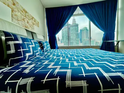a bedroom with a blue and white bed and a window at Vortex suites klcc by Yashrib in Kuala Lumpur