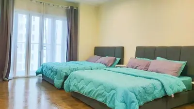 two beds in a bedroom with blue comforter at Setapak Central Mall KL - Zetapark Garden Suites in Kuala Lumpur
