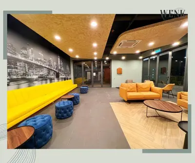 a lobby with a yellow couch and chairs and tables at Neu Suites @ 3rdNvenue 003 in Kuala Lumpur