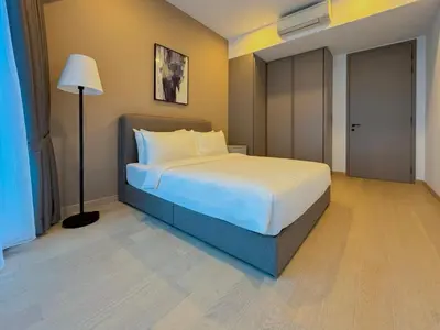 a bedroom with a large bed and a lamp at Eaton Residences by Sutera at KLCC in Kuala Lumpur