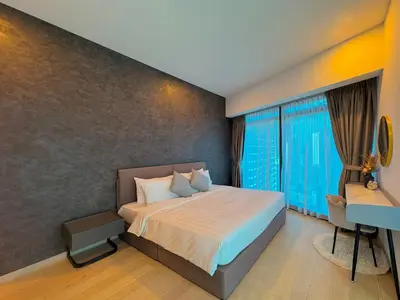 a bedroom with a bed and a desk and windows at Eaton Residences by Sutera at KLCC in Kuala Lumpur