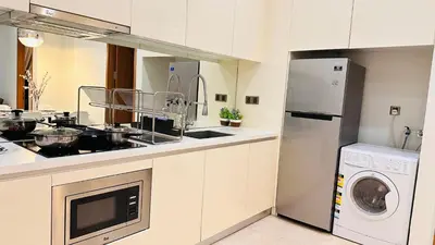 a kitchen with a sink and a washer and dryer at Soho Suites KLCC By Grand KL in Kuala Lumpur