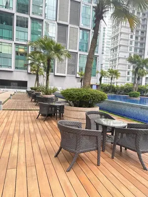a deck with tables and chairs in a building at Soho Suites KLCC By Grand KL in Kuala Lumpur